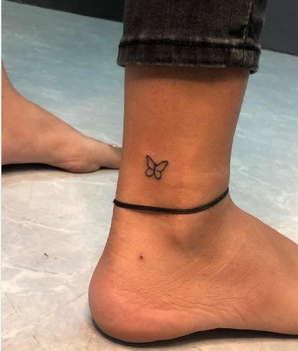 Minimal butterfly tattoo on ankle